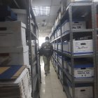 Escena. Un agente fiscal recorre las instalaciones de las bodegas de la Superintendencia de Compañías recopilando información.