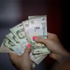 El aumento del salario mínimo en Argentina fue acordado a principios de semana entre representantes sindicales, empresarios y funcionarios estatales. En la imagen un registro de archivo de las manos de una mujer al contar un fajo de billetes de 5 pesos argentinos.