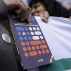 Fotografía de archivo en la que se registró la mano de un hombre al sostener un ejemplar de la propuesta de nueva Constitución chilena.