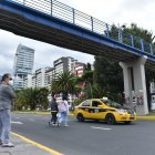 Normalizado. Las personas caminan entre los autos para llegar al otro lado de la calle.