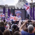 Londres. Gente en el centro comercial viendo a Su Majestad, la Reina en el balcón del Palacio de Buckingham mostrado en una pantalla grande durante las celebraciones del Jubileo de Platino de la Reina Isabel II, el 2 de junio de 2022.