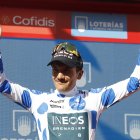 Richard Carapaz levanta los brazos con su maillot de puntos azules.