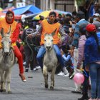 Varias personas con sus burros participan en una carrera, hoy, en Salcedo (Ecuador).