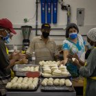Personas preparan arepas en el marco del Día Mundial de este alimento, hoy, en Caracas (Venezuela).