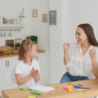 Mom and daughter are happy to finish their homework in the kitchen. Home life. Real joy