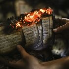 Panorama. Un hombre muestra un ejemplar del Corán en llamas en una mezquita que fue incendiada en Cisjordania en noviembre de 2014.
