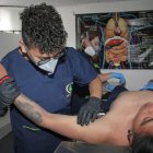 Trabajo. Uno de los estudiantes de Ortiz aprende a reconocer la anatomía y cómo manejar un cuerpo, que en este caso es otro estudiante que simula estar muerto.