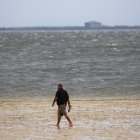 Un hombre camina a lo largo de una costa en Tampa, Florida, EE. UU., el 28 de septiembre de 2022.