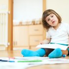 calm two year child sketching on paper in home interior