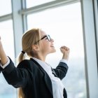 Business woman excited hold hands up raised arms celebrate victory . concept winner success in modern office