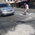 Andrés Romero coloca material de construcción en los huecos que se han formado en la avenida Laurice Anton. Una labor que realiza cada cuatro días.