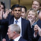 El excanciller de Hacienda británico Rishi Sunak (C) se encuentra rodeado de simpatizantes a su llegada a la Oficina Central del Conservador