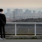 Vista de marzo de 2021 de una persona joven observando el paisaje de Barcelona.