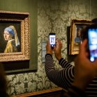 Visitantes toman fotografías de la "Niña de la Perla", del artista holandés Johannes Vermeer, en el Museo Mauritshuis de La Haya, en Países Bajos.