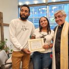 Los migrantes venezolanos Yonaiker Brujo y Nathalie Quintana muestran el certificado de matrimonio junto al sacerdote luterano, el padre Fabián Arias, en la iglesia San Pedro en Manhattan, Nueva York.
