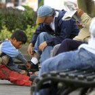 Fotografía de archivo en la que se registró a un niño al trabajar lustrando zapatos en una calle de Quito (Ecuador).