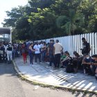 Migrantes hacen fila para intentar resolver su situación migratoria a las afueras del módulo de atención provisional ubicado en el parque ecológico, hoy, en Tapachula (México).
