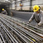 Fábrica.- Los trabajadores construyen columnas de barras de refuerzo en una planta.