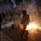 Miembros de la policía vigilan a cientos de manifestantes a favor de Pedro Castillo y en contra del Congreso que se manifiestan en las calles del centro, en Lima (Perú).