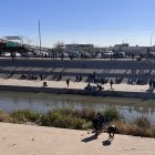 Migrantes esperan para cruzar el río hoy, en la valla fronteriza de El Paso, Texas, frente a Ciudad Juárez, México. EFE/Octavio Guzmán