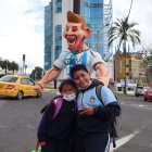 Dos niños posan junto a un monigote de Lionel Messi, el 28 de diciembre de 2022, en Quito (Ecuador).