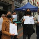 Molestia. Mientras hace fila en el exterior de un banco, un ciudadano indica cuánto pagó el año pasado