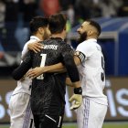 Los jugadores del Real Madrid Marco Asensio (i) y Karim Benzemá (d) felicitan a Thibaut Courtois tras detener el último penalti ante el Valencia.