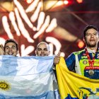 El piloto Sebastián Guayasamín (d) y su celebración con la bandera ecuatoriana tras concluir el rally Dakar.