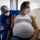 Personal médico aplica una dosis de la vacuna Moderna a una mujer embarazada.