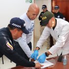 Fotografía cedida hoy, por la Policía Nacional de Colombia, que muestra integrantes de la Organización Internacional de Policía Criminal Interpol, mientras custodian al ciudadano colombiano Álvaro Córdoba