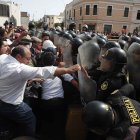 Policías chocan con ciudadanos junto a la sede de la Prefectura, donde se encuentran los manifestantes detenidos, en Lima