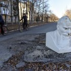 Dos personas en bicicleta pasan frente al busto de Vladimir Lenin, que cubre el cráter de los bombardeos en la carretera en la ciudad recuperada de Lyman, en la región de Donetsk, en el este de Ucrania.