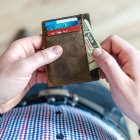 HOMBRE SOSTENIENDO BILLETERA CON TARJETAS Y DINERO EN EFECTIVO |