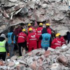 Personal de emergencia y lugareños buscan víctimas en el lugar de un edificio derrumbado tras un fuerte terremoto en el distrito de Elbistan de Kahramanmaras, sureste de Turquía