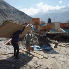 Personas caminan entre los escombros ocasionados por el alud en el pueblo de Secocha en Arequipa (Perú).