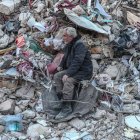 Un hombre se sienta sobre los escombros mientras espera noticias de su familia en el sitio de los edificios derrumbados después de un fuerte terremoto, en Hatay, Turquía, el 15 de febrero de 2023.