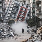 Una mujer pasa junto a edificios en ruinas, tras los terremotos de Turquía.