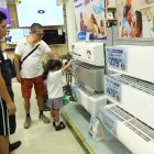 Unos clientes cotizan los equipos de climatización que ofrece la tienda en el local ubicado en Plaza Mayor, en la Alborada.
