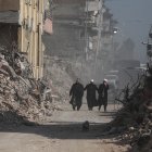La gente pasa frente a los edificios derrumbados tras los fuertes terremotos en Hatay, Turquía, el 23 de febrero de 2023.
