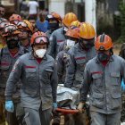 Bomberos llevan el cuerpo de dos víctimas hoy, en el distrito de Barra do Sahy, en la ciudad de Sao Sebastiao (Brasil).