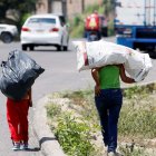 Dos niños cargan bolsas donde llevan botes plásticos para reciclar en Olancho (Honduras), en una fotografía de archivo.