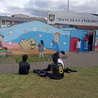 Cuenca. El trío de mujeres trabaja en el mural de una escuela local.