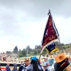 El rey carnaval aparece en medio de un grupo personas, bailando.