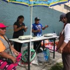 Una postal tradicional del día de elecciones. Personas ofrecen emplasticar el certificado de votación.