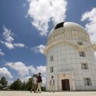 Tres personas caminan frente al observatorio Gaomeigu, fuera de Lijiang al suroeste de la provincia china de Yunnan, uno de los mayores del este de Asia .