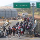 Migrantes caminan en caravana en una carretera de México.