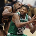 El alero de los Cleveland Cavaliers, Evan Mobley (i), defiende contra el escolta de los Boston Celtics, Marcus Smart (der.), durante el partido en el Rocket Mortgage Fieldhouse de Cleveland.
