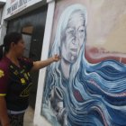 Presencia. Una persona admira retrato de Maura Alejandro.