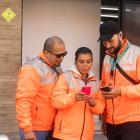 Trabajadores.- Tres personas revisan la aplicación de delivery con la que laboran.