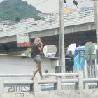 Un mujer camina sobre el tubo de un puente en el norte de la ciudad.